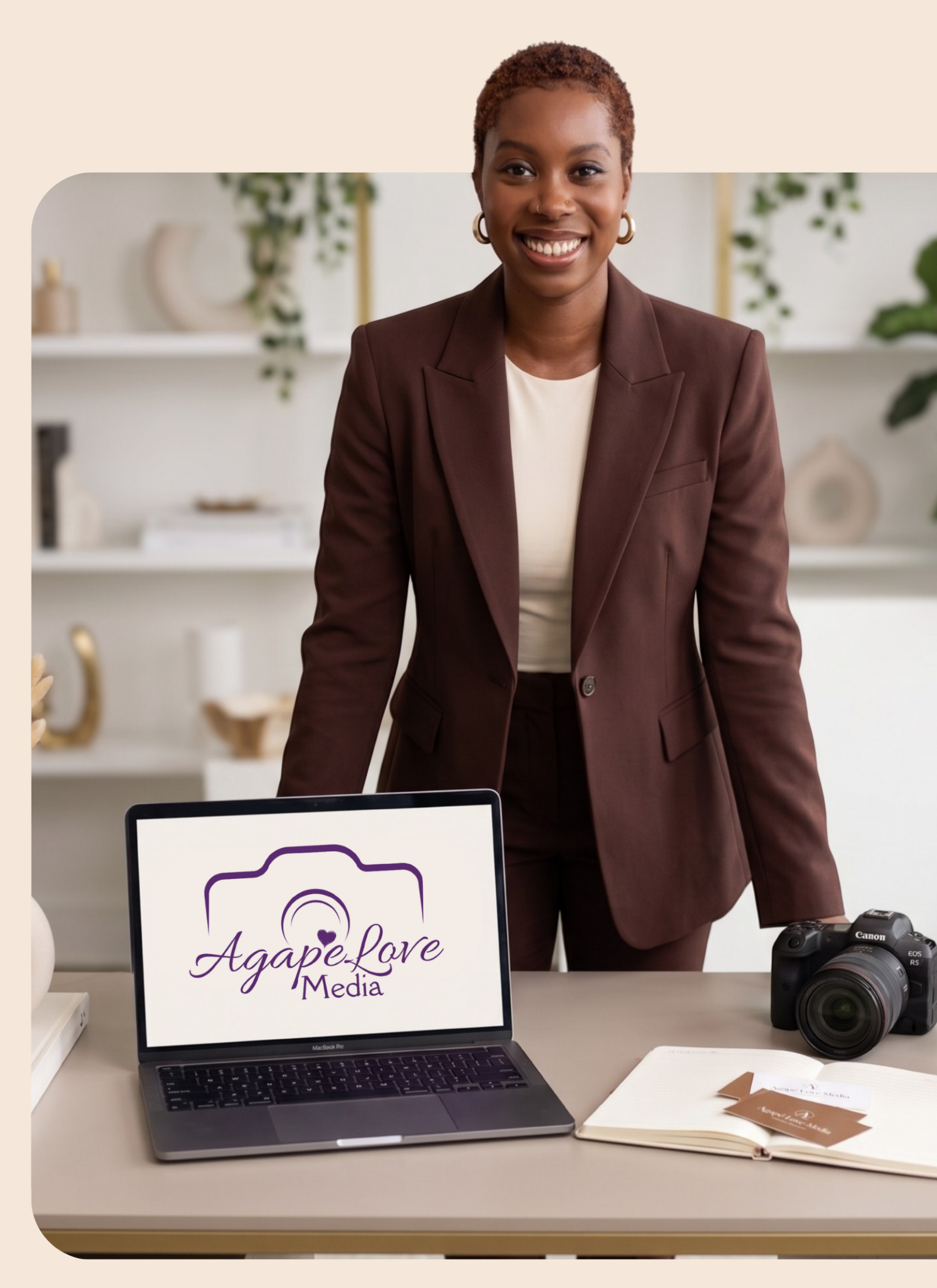 Agapé behind a desk with a laptop showing the Agapé Love Media logo